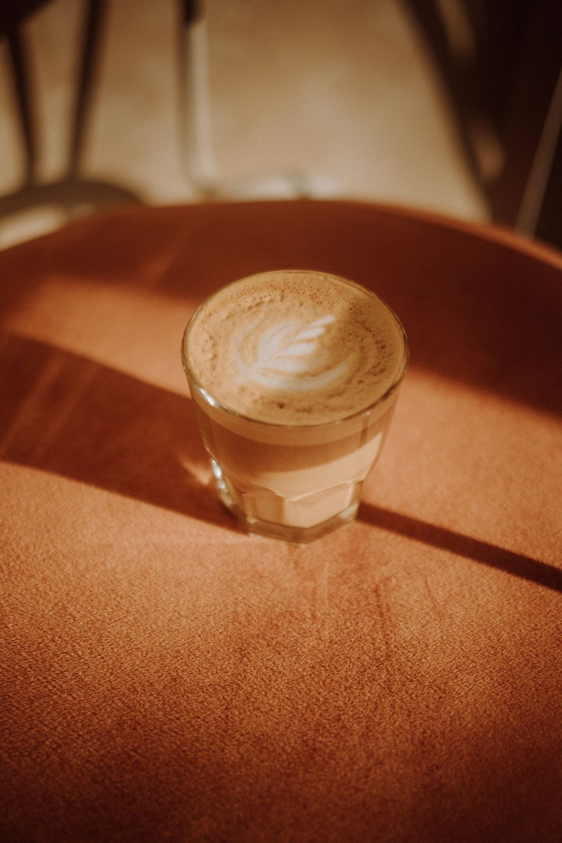 Warm and inviting latte with latte art in a cozy, sunlit café ambiance.