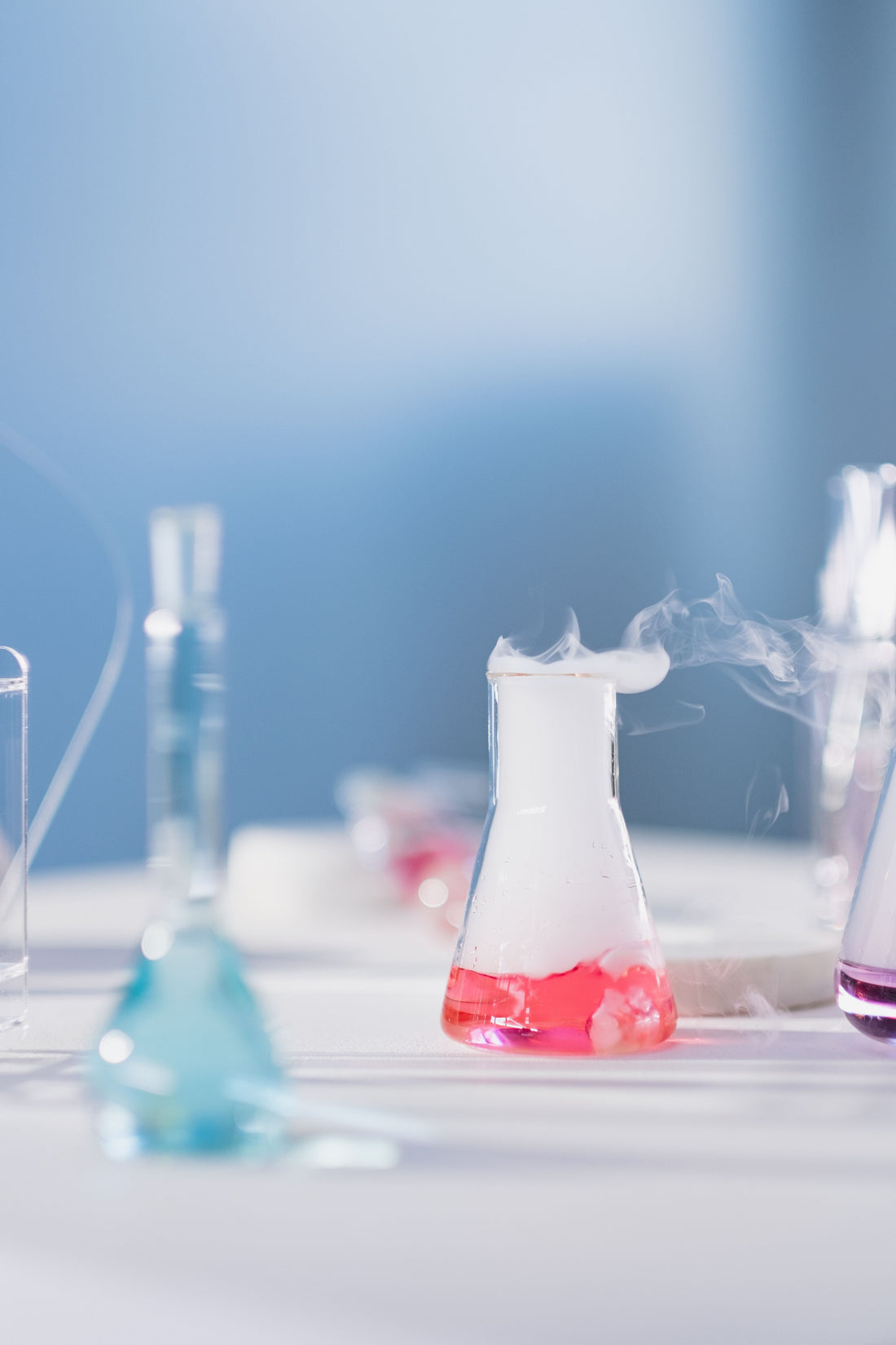 Illustrative laboratory flasks with colored liquid and vapor