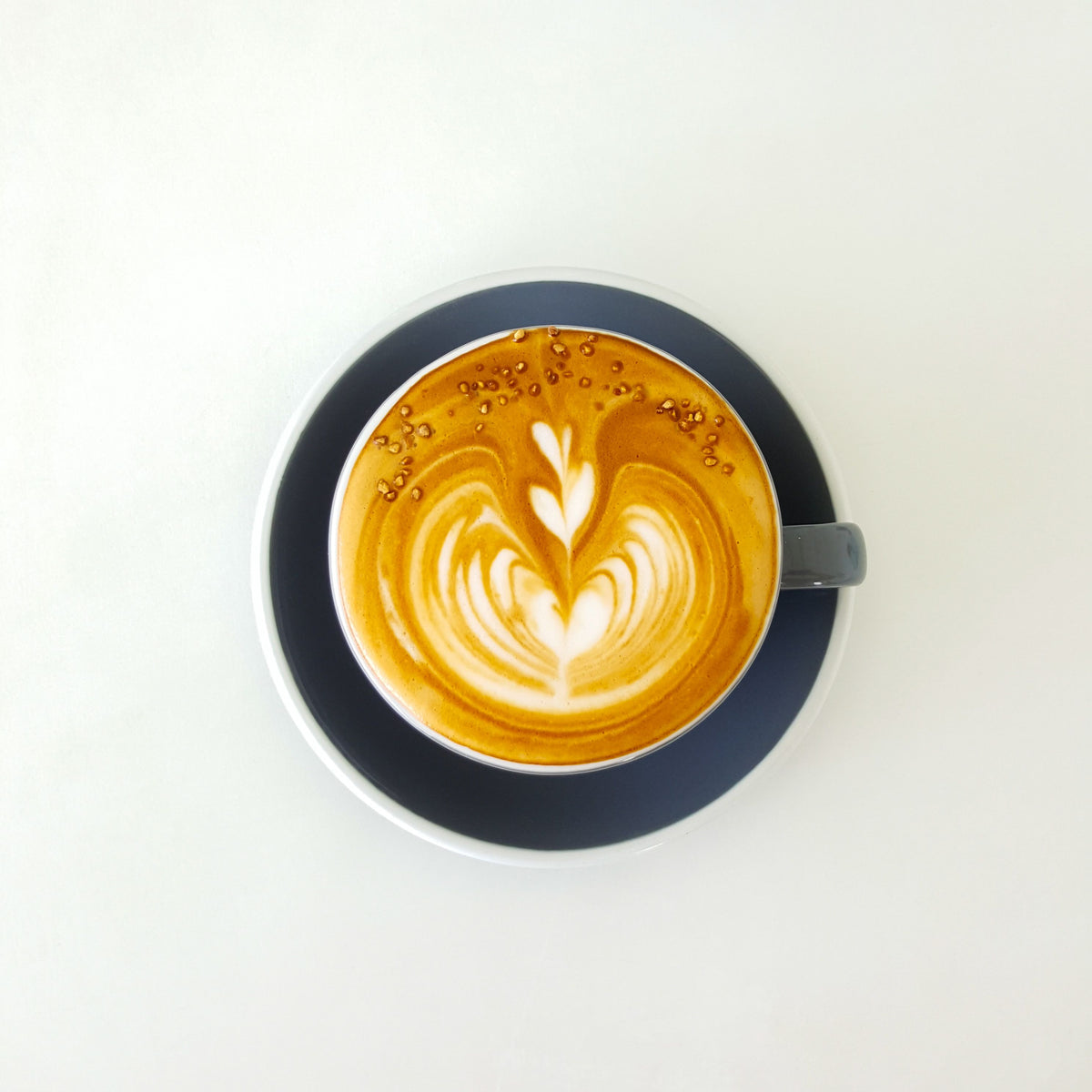 Overhead view of coffee with milk foam art in a cup and saucer