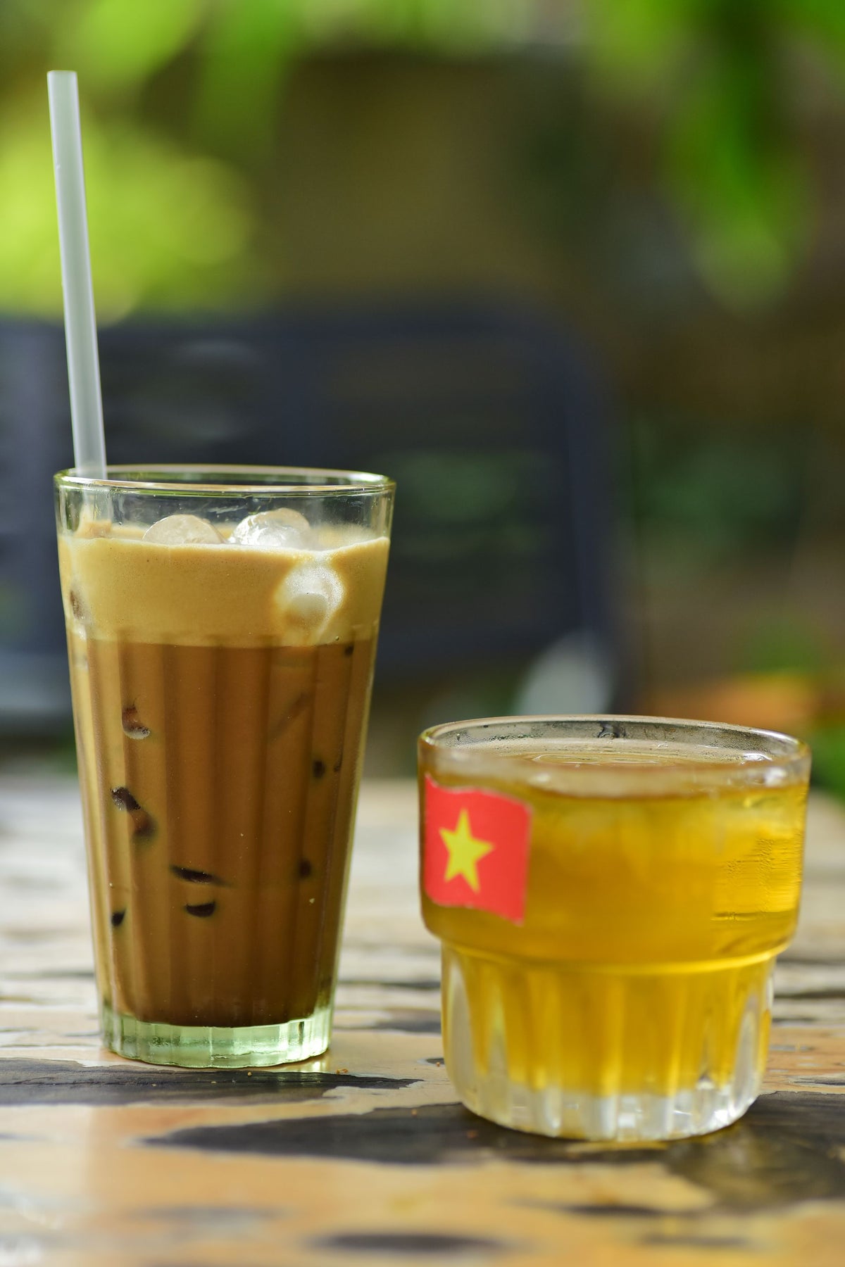 Refreshing Vietnamese iced coffee and tea with flag glass, perfect for summer enjoyment outdoors.